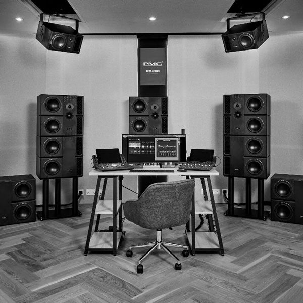 Monitores PMC junto a escritorio con equipamiento de audio