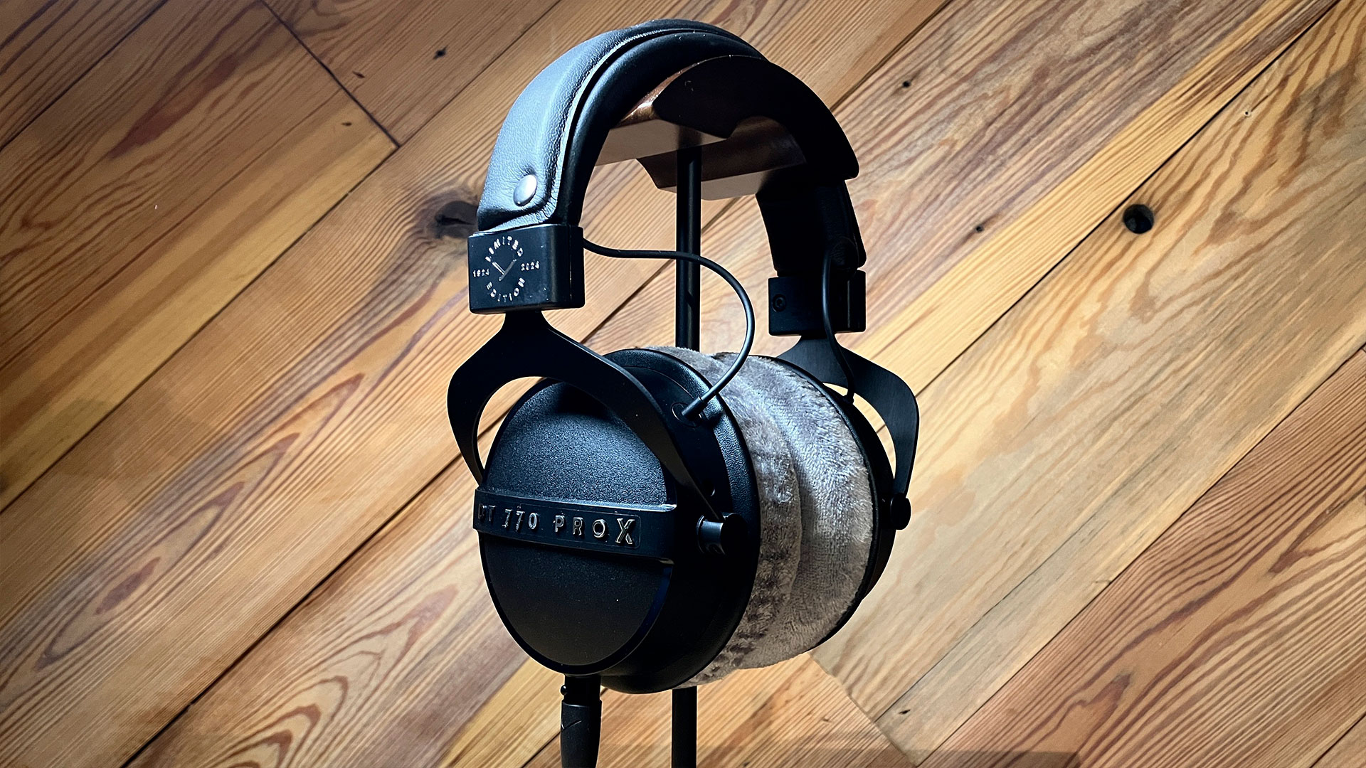 Beyerdynamic DT770 Pro en soporte, sobre fondo de madera